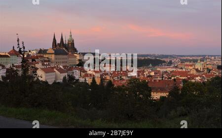 Die Prager Burg, der Veitsdom und die kleine Stadt (Malá Strana), die vom Petrin-Hügel bei Sonnenuntergang in Prag aus gesehen werden Stockfoto