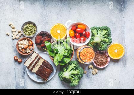 Pflanzliche Quellen von Eisenhintergrund. Haferflocken, Linsen, Tofu, Brokkoli, getrocknete Aprikosen und Nüsse sind eisenreiche Lebensmittel. Stockfoto