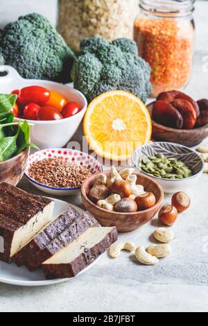 Pflanzliche Quellen von Eisenhintergrund. Haferflocken, Linsen, Tofu, Brokkoli, getrocknete Aprikosen und Nüsse sind eisenreiche Lebensmittel. Stockfoto