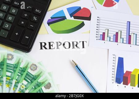 Erstellung des Finanzberichts. Geld, Rechner, Stift, Farbdiagramme und Diagramme auf dem Tisch. Zusammenfassung des Zeitraums Stockfoto