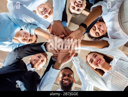 Mitarbeiter, Die Während Der Besprechung Im Büro In Den Händen Der Circle Holding Stehen Stockfoto