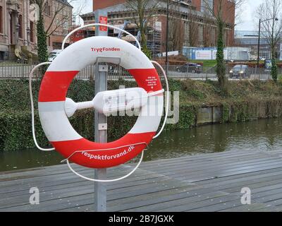 Aarhus, Dänemark - 16. März 2020 - Lifebuoy am Ufer in Aarhus, Dänemark. Rot-weiße Rettungsschwimmerhalle Stockfoto