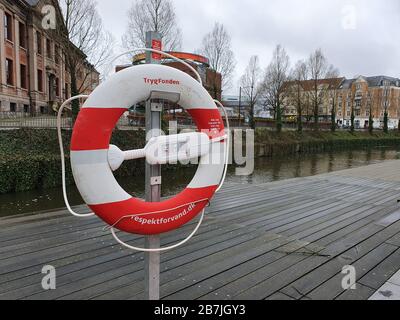 Aarhus, Dänemark - 16. März 2020 - Lifebuoy am Ufer in Aarhus, Dänemark. Rot-weiße Rettungsschwimmerhalle Stockfoto