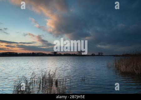 Beleuchtete Wolken nach Sonnenuntergang auf dem See Stockfoto