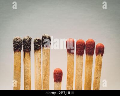 Matchstäbchen brennen, ein Stück verhindert die Brandausbreitung - das Konzept, wie man das Coronavirus davon abhält, sich zu verbreiten: Isolation, zu Hause zu bleiben und Stockfoto