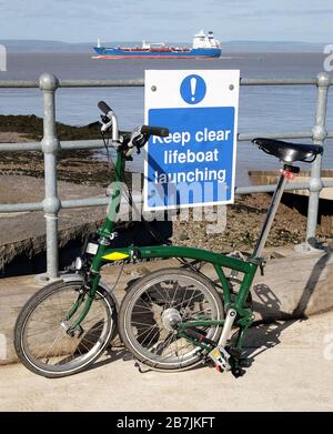 März 2020 - Green Brompton Klapprad an der Startrampe des Rettungsbootes in Portishead Stockfoto