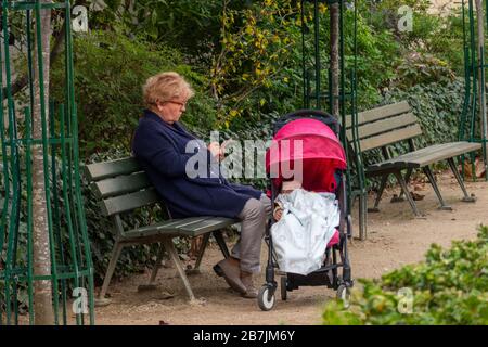 Großmutter sitzt mit Baby in einem Park in Paris Frankreich Stockfoto