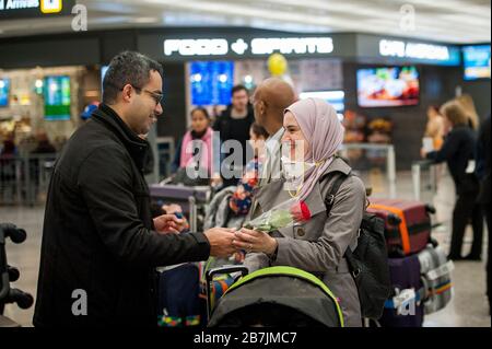 Eine Familie ist vereint, wenn Passagiere aus Dubai nach einem 14-stündigen Flug auf Emirates-Flug 231 am internationalen Terminal am Dulles International Airport in Dulles, Virginia, Montag, 16. März 2020 ankommen. Einige Leute ergreifen die Vorsorge, Gesichtsmasken zu tragen, wenn sie ankommen, um von Familie und Freunden begrüßt zu werden. Kredit: Rod Lamkey/CNP /MediaPunch Stockfoto