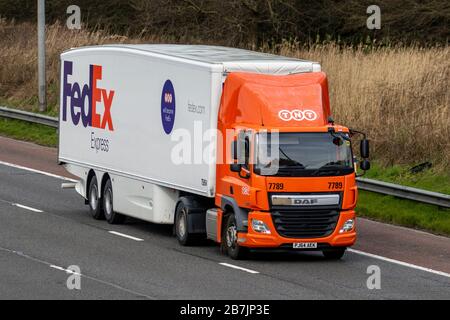 FedEx Transport-Lieferwagen, orangefarbener weißer Lkw, Transport, LKW, Frachtführer, DAF-Fahrzeug, europäischer kommerzieller Transport, Industrie, M6 in Manchester, Großbritannien Stockfoto