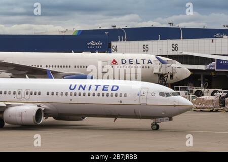 SEATTLE TACOMA AIRPORT, WA, USA - JUNI 2018: United Airlines Boeing 737 bei der Abfahrt mit dem Taxi an einem Delta Airlines-Flugzeug am Seattle Tacoma Airport vorbei. Stockfoto
