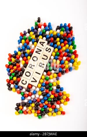 Karte von Deutschland mit Text-Corona-Virus in der Mitte, in mehreren Farben, die alle Nationalitäten repräsentieren, die in Deutschland leben, mit Holzfigürchen gebaut Stockfoto