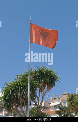 Flatternde albanische Flagge blauer Himmel im Hintergrund Stockfoto