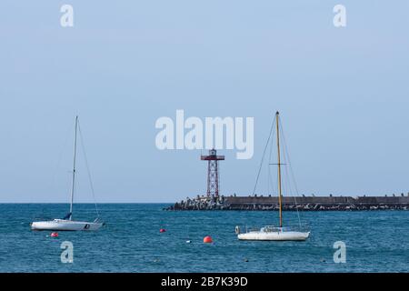 Segelboote Und Leuchtfeuer-Leuchtturm Von Harbor Stockfoto