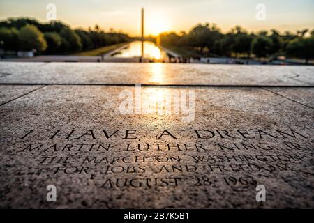 WASHINGTON DC, Vereinigte Staaten – die Sonne geht hinter dem Washington Monument auf, von der Stelle aus, an der Dr. Martin Luther King Jr seine berühmte „I have a Dream“-Rede auf den Stufen des Lincoln Memorial in Washington DC gehalten hat. In die Marmortreppe ist eine Gedenktafel eingeätzt, die an die Stelle erinnert. Stockfoto