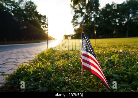 WASHINGTON DC, USA – das Vietnam Veterans Memorial, entworfen von Maya Lin, beleuchtet durch das sanfte Licht des Sonnenaufgangs. Die Wände aus schwarzem Granit mit den Namen gefallener Soldaten spiegeln den frühen Morgenhimmel wider und schaffen eine feierliche und reflektierende Atmosphäre in der National Mall. Stockfoto