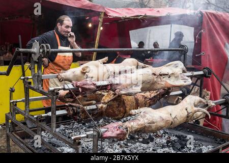 KACAREVO, SERBIEN - 18. FEBRUAR 2017: Der Mann brate auf einem traditionellen Grill Serbiens auf dem Balkan ein Schwein und ein Lamm, genannt Pecenje auf einem Markt. Por Stockfoto