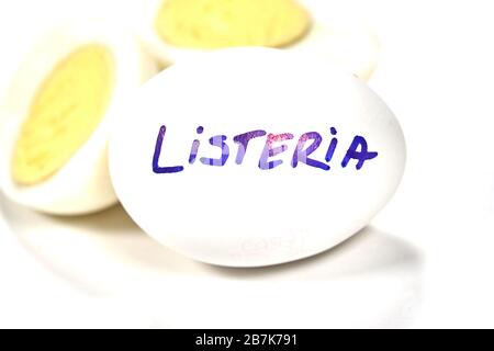 Hart gekochtes Ei mit Listeria auf Ei schreiben. Listeriose ist eine lebensmittelbedingte Infektion, die durch Listeria-Bakterien verursacht wird. Listeria wird durch Bakterien verursacht, die c Stockfoto