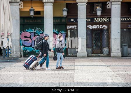 Madrid, Spanien. März 2020. Touristen mit Koffern gehen an der Plaza Mayor entlang.Spanien hat es mit seiner ersten werktätigen Sperrung an diesem Montag zu tun, da die Zahl der Coronavirus an einem Tag um rund 1.000 auf 8.744 anschwellen. Die neuesten Zahlen deuten darauf hin, dass 3.200 Menschen in Krankenhäusern behandelt werden, 410 auf Intensivstationen, während 300 aufgrund des Virus, der als COVID-19 bekannt ist, starben. Etwa 40 % der Patienten mit bestätigten Fällen wurden ins Krankenhaus eingeliefert. Credit: SOPA Images Limited/Alamy Live News Stockfoto