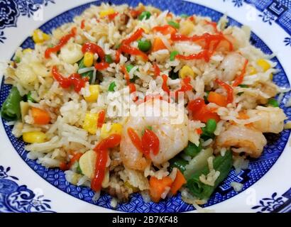 Gebratener Reis mit Garnelen, gemischtem Gemüse und Sriracha-Sauce Stockfoto