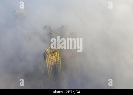 Wolkenkratzer sind vom Nebel in der Stadt Huaibei, der ostchinesischen Provinz Anhui, am 12. Februar 2020, umgeben. Stockfoto