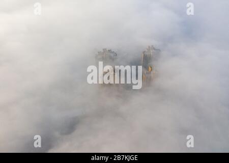 Wolkenkratzer sind vom Nebel in der Stadt Huaibei, der ostchinesischen Provinz Anhui, am 12. Februar 2020, umgeben. Stockfoto