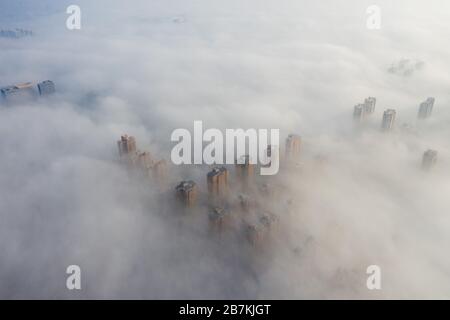 Wolkenkratzer sind vom Nebel in der Stadt Huaibei, der ostchinesischen Provinz Anhui, am 12. Februar 2020, umgeben. Stockfoto