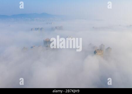 Wolkenkratzer sind vom Nebel in der Stadt Huaibei, der ostchinesischen Provinz Anhui, am 12. Februar 2020, umgeben. Stockfoto