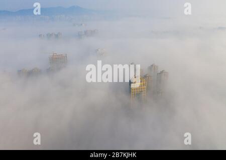 Wolkenkratzer sind vom Nebel in der Stadt Huaibei, der ostchinesischen Provinz Anhui, am 12. Februar 2020, umgeben. Stockfoto