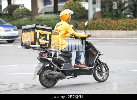 --FILE--Deliverymen von verschiedenen Plattformen, die Online-Service für Lebensmittelbestellung anbieten, liefern Lebensmittel, indem sie Elektrofahrrad in Shanghai, China, am 28. Juli 2 fahren Stockfoto