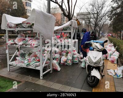 Die Lieferer stellen Lieferungen an die Abholstation für E-Commerce-Lieferungen an der Bajiao Road in Peking, China, am 14. Februar 2020. Stockfoto