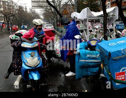 Die Lieferer stellen Lieferungen an die Abholstation für E-Commerce-Lieferungen an der Bajiao Road in Peking, China, am 14. Februar 2020. Stockfoto