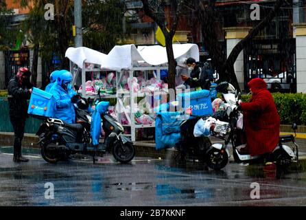 Die Lieferer stellen Lieferungen an die Abholstation für E-Commerce-Lieferungen an der Bajiao Road in Peking, China, am 14. Februar 2020. Stockfoto