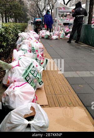 Die Lieferer stellen Lieferungen an die Abholstation für E-Commerce-Lieferungen an der Bajiao Road in Peking, China, am 14. Februar 2020. Stockfoto