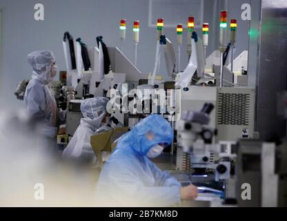 Arbeiter, die in einem High-Tech-Unternehmen Schutzkleidung tragen, nachdem sie lange Ferien auf dem Frühlingsfest im Kreis Sihong, Suqian City, im Osten Chinas Jiangs, verbracht haben Stockfoto