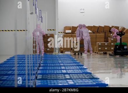 Arbeiter, die in einem High-Tech-Unternehmen Schutzkleidung tragen, nachdem sie lange Ferien auf dem Frühlingsfest im Kreis Sihong, Suqian City, im Osten Chinas Jiangs, verbracht haben Stockfoto