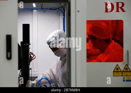Arbeiter, die in einem High-Tech-Unternehmen Schutzkleidung tragen, nachdem sie lange Ferien auf dem Frühlingsfest im Kreis Sihong, Suqian City, im Osten Chinas Jiangs, verbracht haben Stockfoto