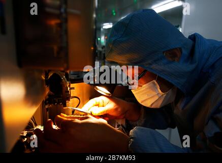 Arbeiter, die in einem High-Tech-Unternehmen Schutzkleidung tragen, nachdem sie lange Ferien auf dem Frühlingsfest im Kreis Sihong, Suqian City, im Osten Chinas Jiangs, verbracht haben Stockfoto