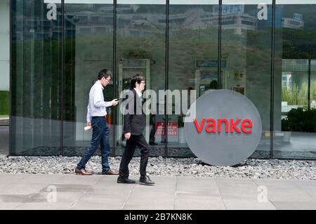 In diesem nicht lokalisierten und undatierten Foto gehen Fußgänger am Logo von Vanke, einem großen Wohnimmobilienentwickler, vorbei. *** Lokale Beschriftung *** fachaos Stockfoto