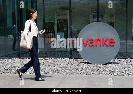 In diesem nicht lokalisierten und undatierten Foto gehen Fußgänger am Logo von Vanke, einem großen Wohnimmobilienentwickler, vorbei. *** Lokale Beschriftung *** fachaos Stockfoto
