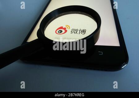 Kreatives Foto: Das Logo von Sina Weibo, einer chinesischen Microblogging-Website (weibo) ähnlich wie Twitter, wird auf einem Smartphone gezeigt, wie der Besitzer es verwendet. Stockfoto