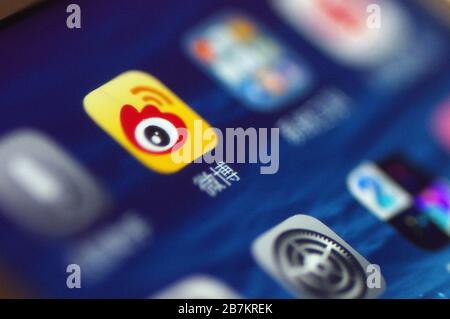 Kreatives Foto: Das Logo von Sina Weibo, einer chinesischen Microblogging-Website (weibo) ähnlich wie Twitter, wird auf einem Smartphone gezeigt, wie der Besitzer es verwendet. Stockfoto