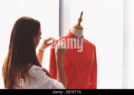 Modedesigner-Studio zur Messung von Textilmaterial Nähmaterial von Frau Designerin stilvoller Showroom / Designer arbeitet professionell messen Stockfoto