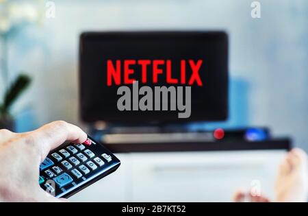 Mai 2017 In Barnaul Russland Statt. Ein junger Mann beobachtet Netflix auf seinem Fernseher und zu Hause. TV-Fernbedienung im Vordergrund, verschwommener Hintergrund auf dem Fernseher. Stockfoto