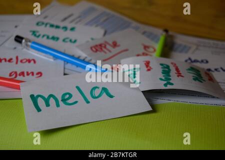 Mela schreibt auf eine Haftnotiz, wie es heißt, apple isoliert auf dem Office Desk. Lernen Sie das Konzept der italienischen Sprache Stockfoto