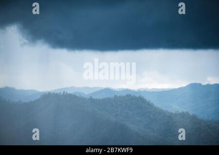 Landschaftsbild von grünen Regenwaldhügeln an regnerischen Tagen mit bewölktem Himmel Stockfoto