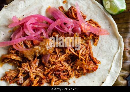 Mexikanischer Tacos von Cochinita Pibil, gebratenes mariniertes Schweinefleisch, serviert mit Habanero-Sauce im Yucatan-Stil und pink eingelegten Zwiebeln Stockfoto