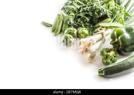 Grünes frisches Gemüse isoliert auf weißem Hintergrund. Zwiebelgurke Erbsen Brokkoli Zucchini und anderes gesundes Gemüse Stockfoto