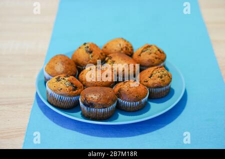 Nahaufnahme von frisch gebackenen Muffins auf einem blauen Teller Stockfoto