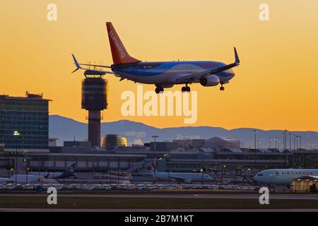 Richmond, British Columbia, Kanada. März 2020. Eine Sunwing Airlines Boeing 737-800 (C-GWVB) Passagierjet landet bei Sonnenuntergang, Vancouver International Airport, Richmond, B.C., Kanada am Montag, 16. März 2020. Am Anfang des Tages verkündete die kanadische Regierung im Bemühen, die Verbreitung des neuartigen Coronavirus zu stoppen, dass die Grenzen der Nation ab Mittwoch, dem 18. März, für alle Reisenden außer kanadischen Bürgern und ständigen Bewohnern, US-Bürgern und Diplomaten und wichtigen Arbeitern geschlossen werden. Kredit: Bayne Stanley/ZUMA Wire/Alamy Live News Stockfoto