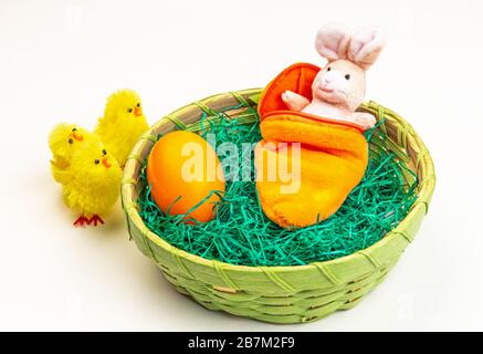 Osterhase aus Stoff in einem Schlafsack im Osterkorb Stockfoto